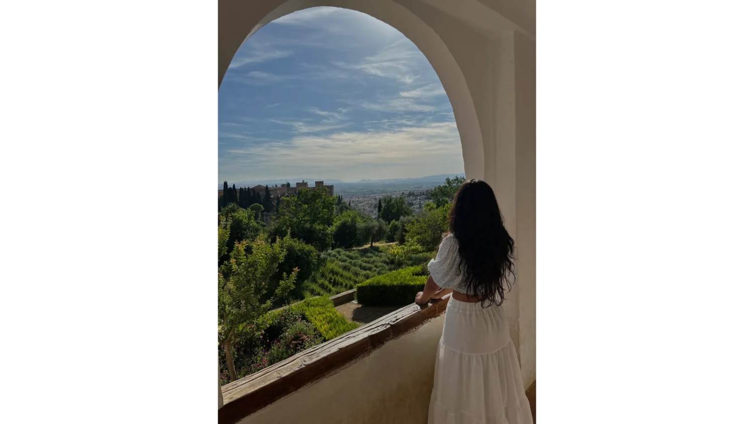 An Arcadia student looks out at the vast countryside from underneath a white arch in Granada, Spain.
