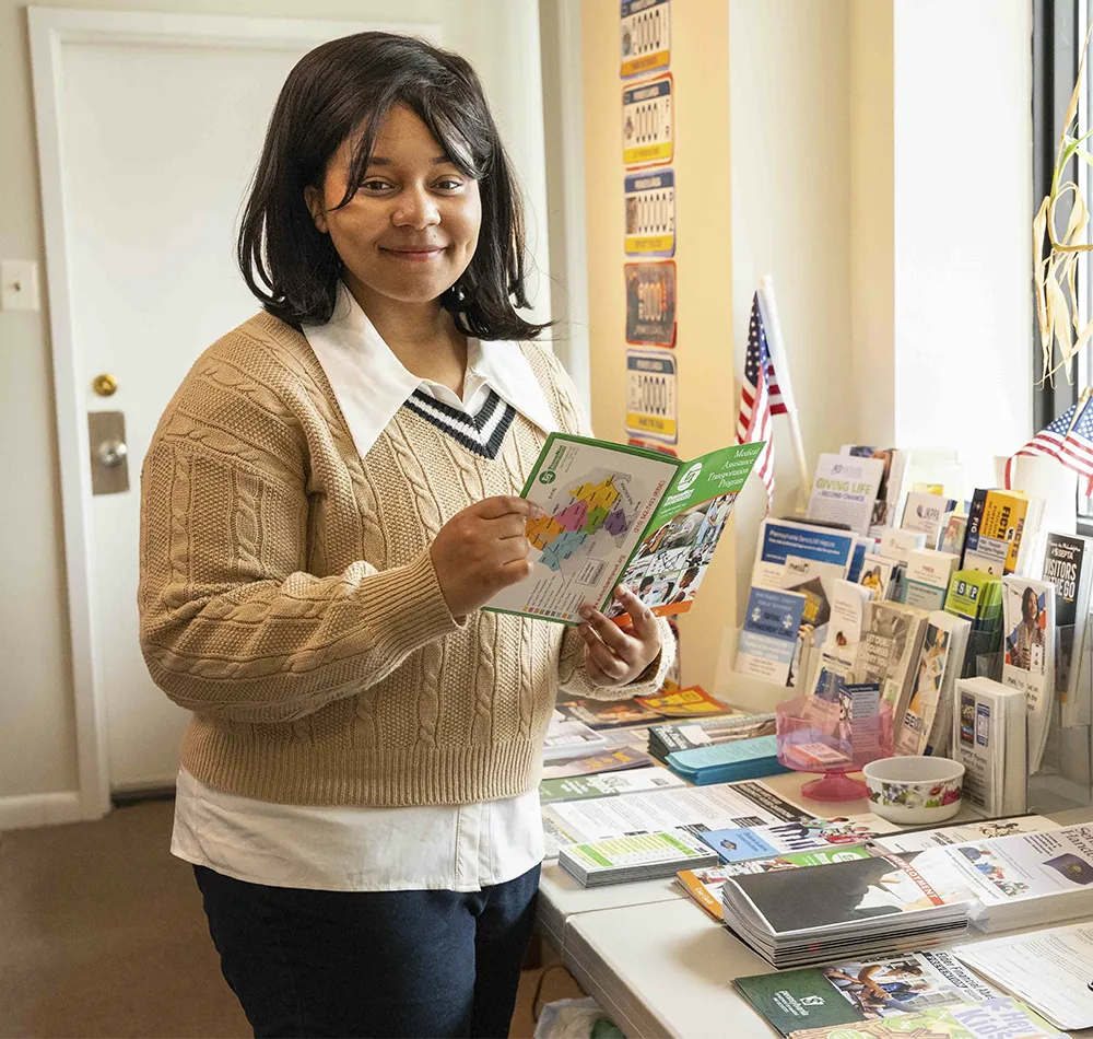 An Arcadia student looks at a map booklet in an office.