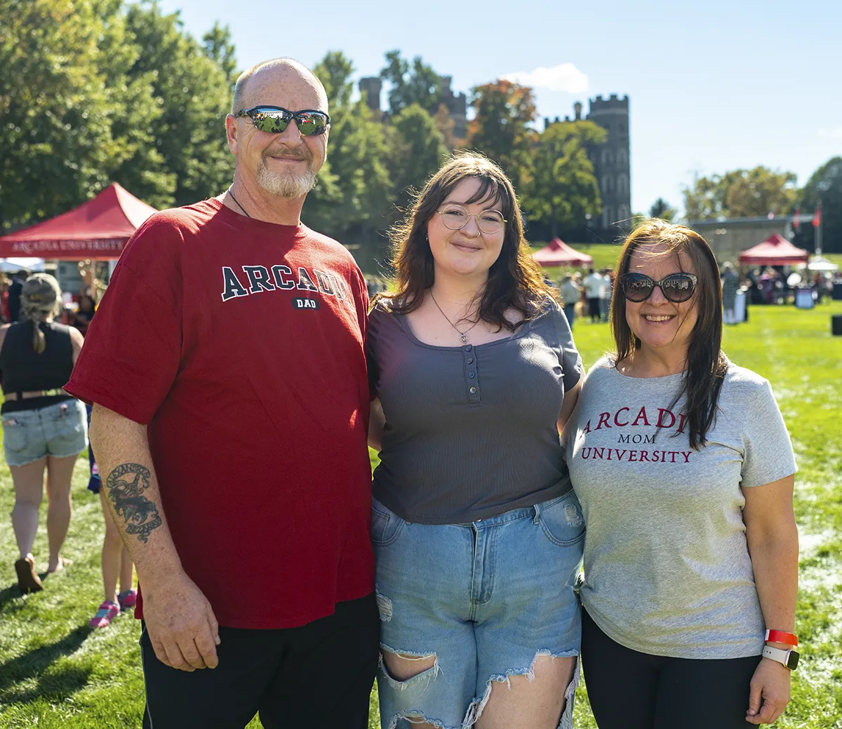 A family of three has fun during a large event on the green at Arcadia.