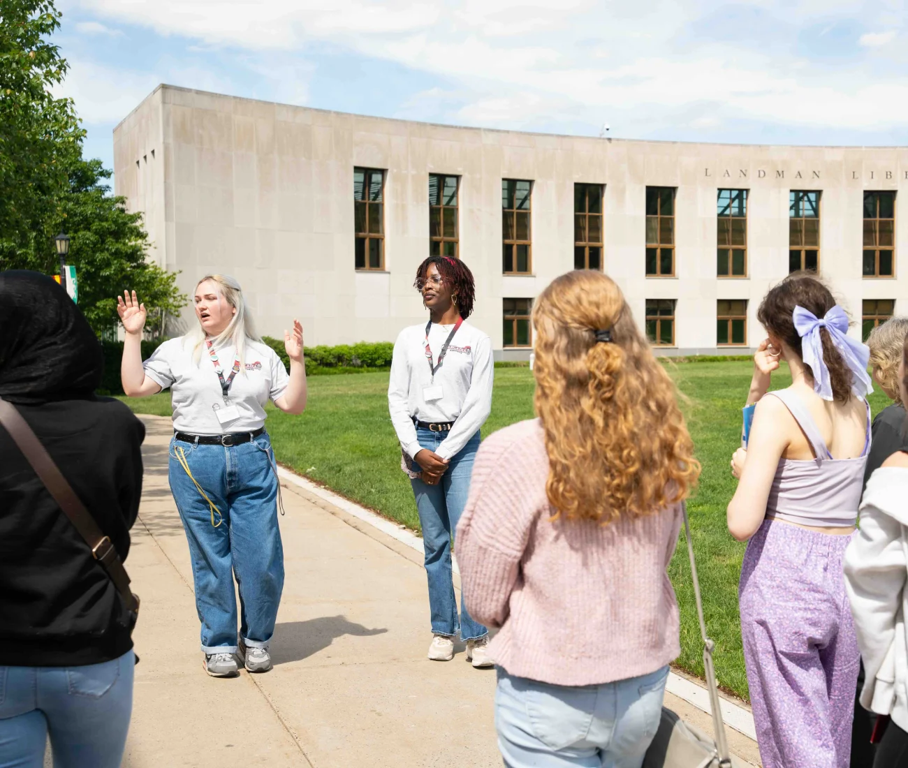 Two students in white Arcadia shirts lead students on a tour to the Landman Library.