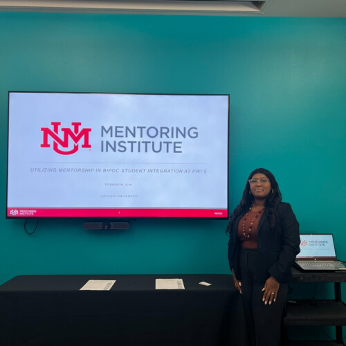 Dr. Robinson standing in front of a screen reading "Mentoring Institute"