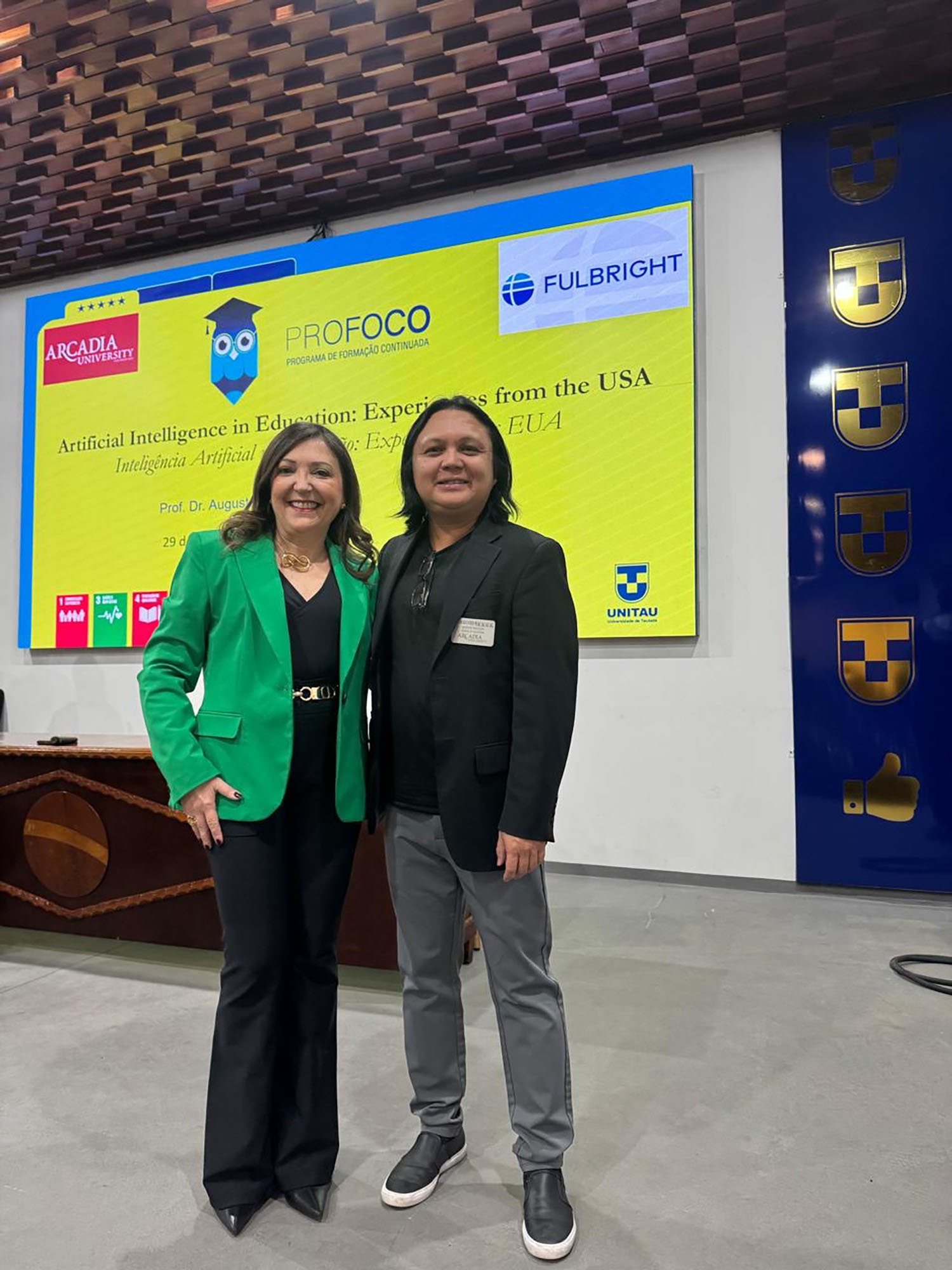Dr. Macalalag standing with someone in front of a screen.