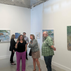 Faculty and staff discussing Sakaguchi's artwork in the Spruance Gallery.