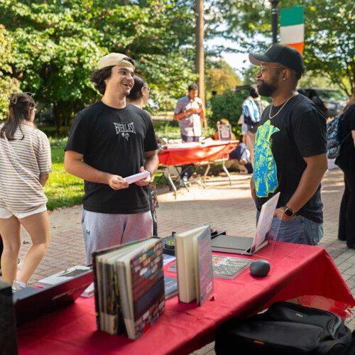 a Students talking with an instructor at the Study Abroad fair.