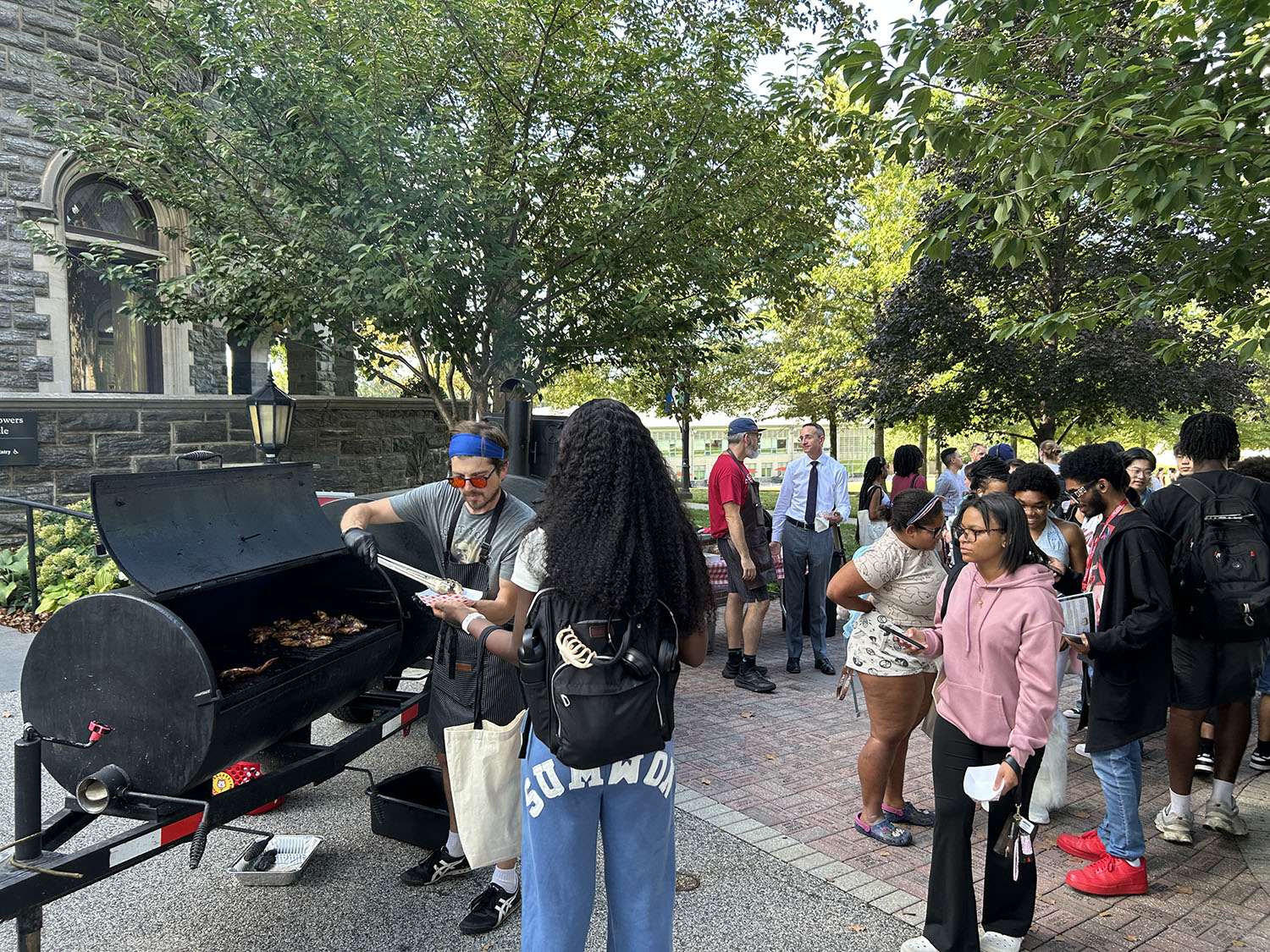 Students getting BBQ from Dr. Brasof's Preview table.