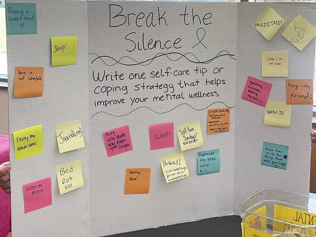 An event table display showcases messages on how to break the silence with self care tips.