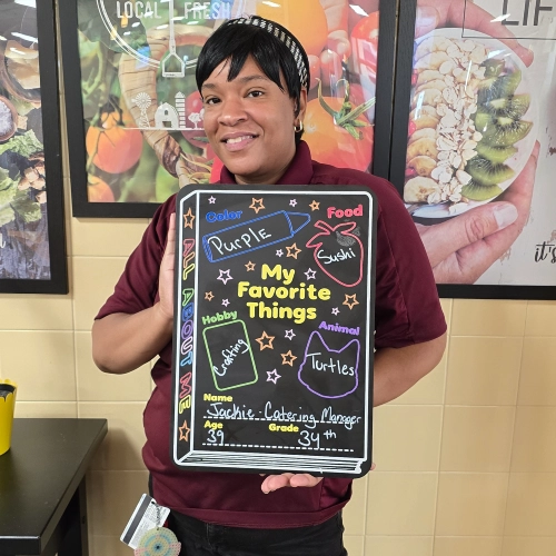 Jackie Banks holding a "My Favorite Things" chalkboard.