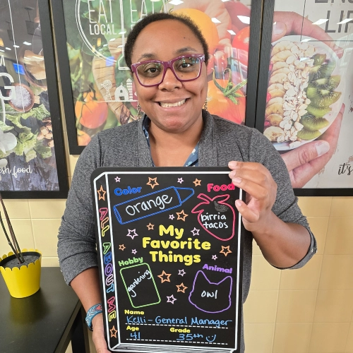 Kelli Johnson holding a "My Favorite Things" chalkboard.