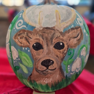A painting of a deer on a pumpkin.
