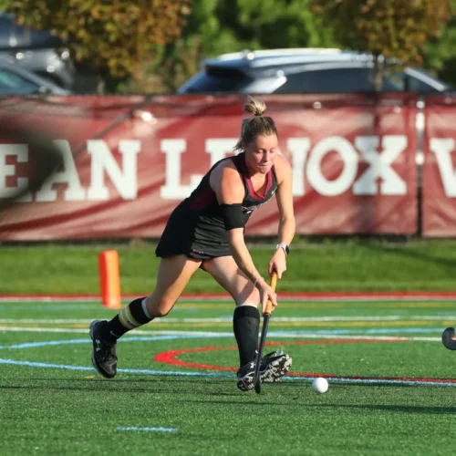 Regan playing field hockey as a student athlete on the field hockey team.