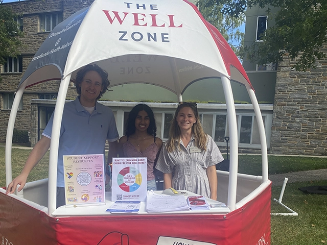 Health counselors stand in an event tent entitles The Wellness Zone.