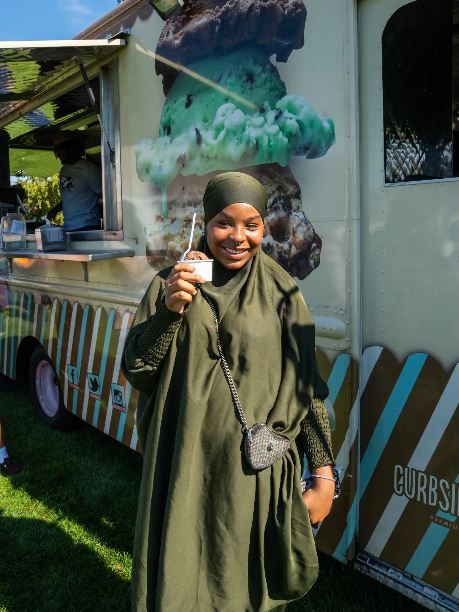 A woman holds up an ice cream cone in front of a food truck at Arcadiafest.