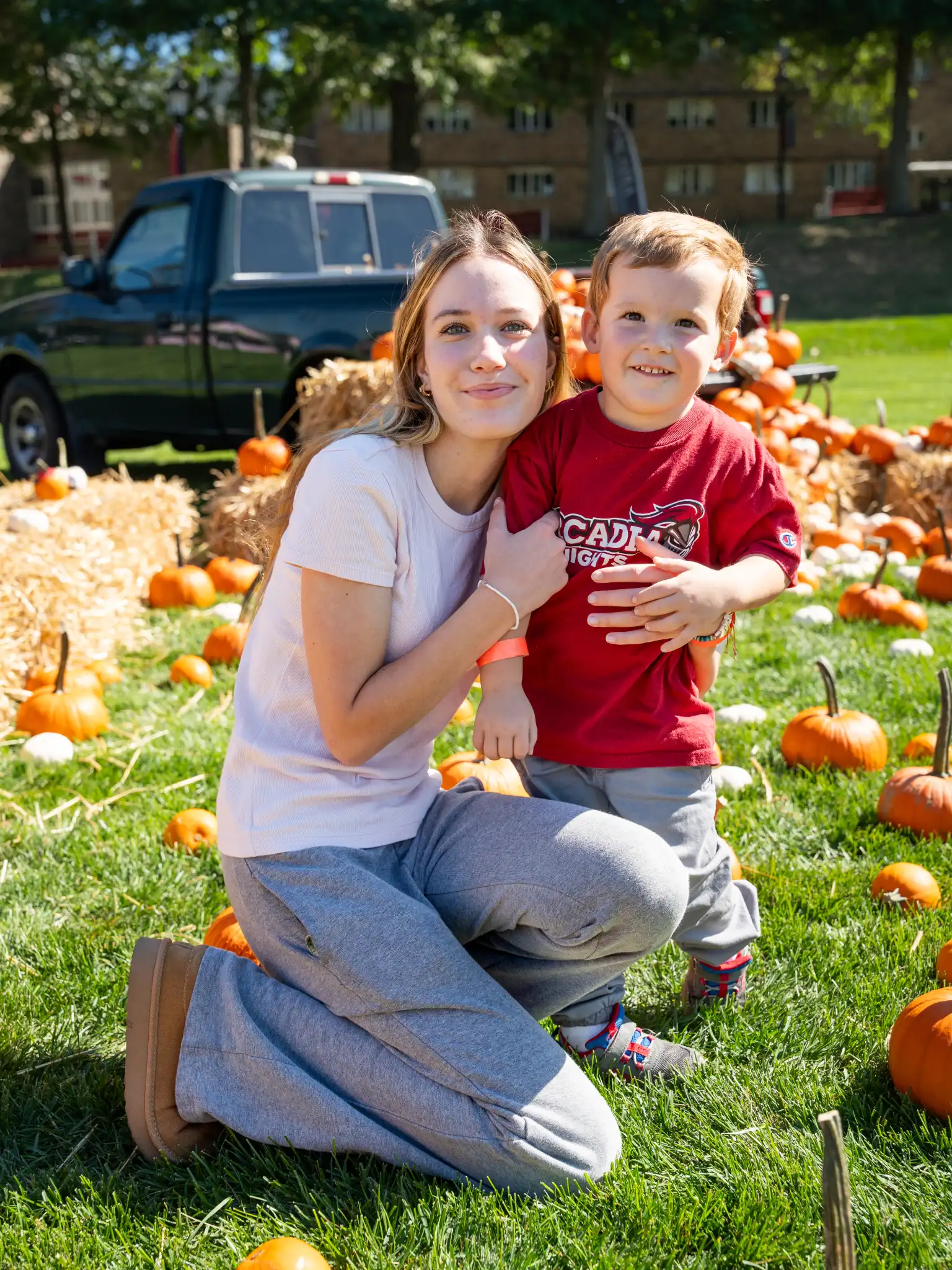 A woman poses with a toddler among the pumpkin patch setup on the Haber Green during Arcadiafest.