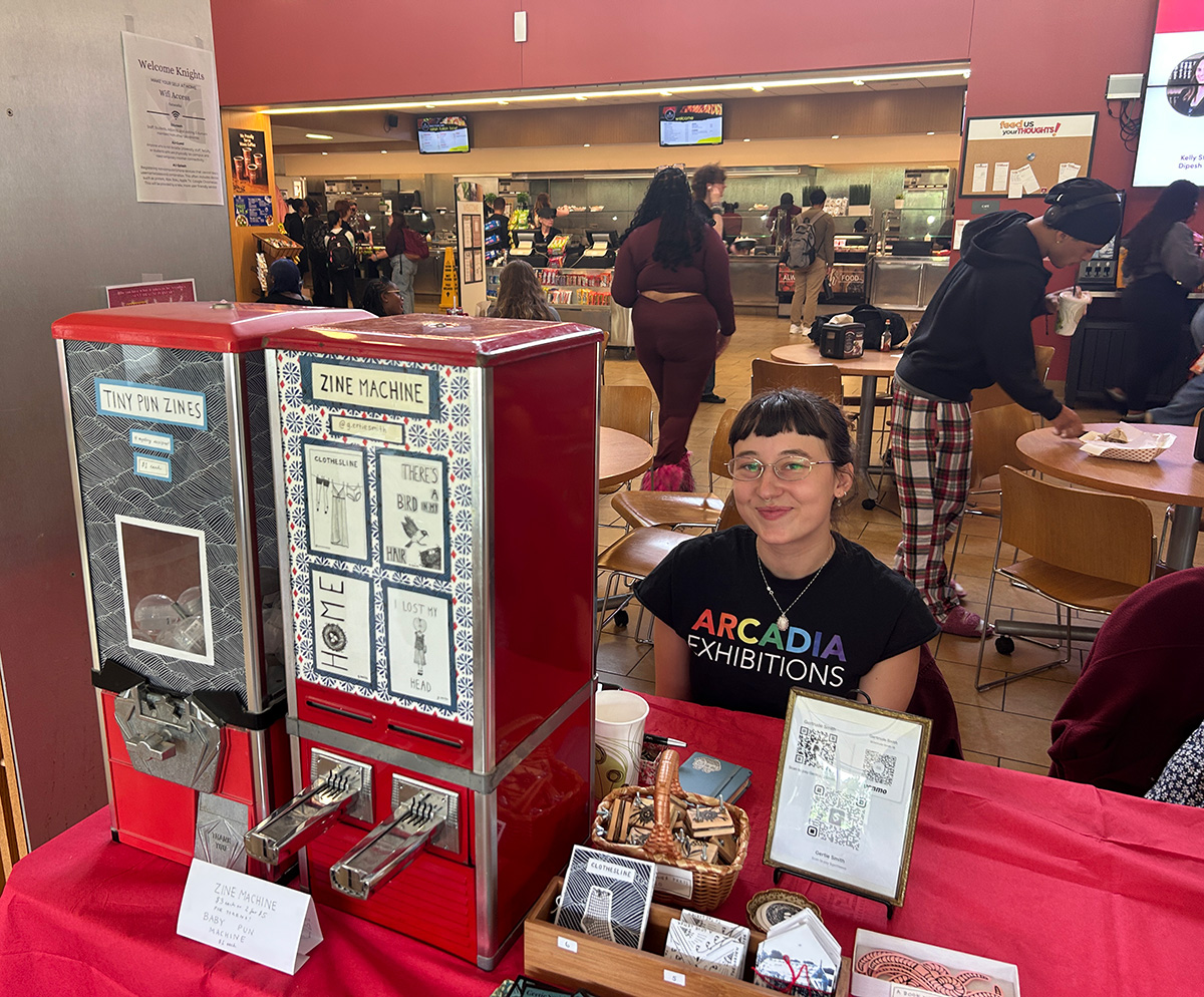 Gertie Smith, a junior at Arcadia, sits behind a table where she sells her art creations out of a gumball machine.