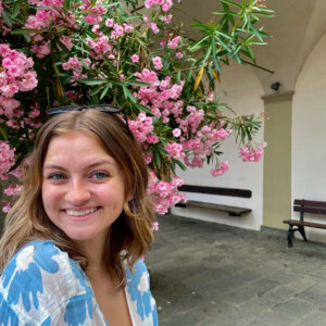 Alexis Bowser ’25MEd with a flowering tree behind her.
