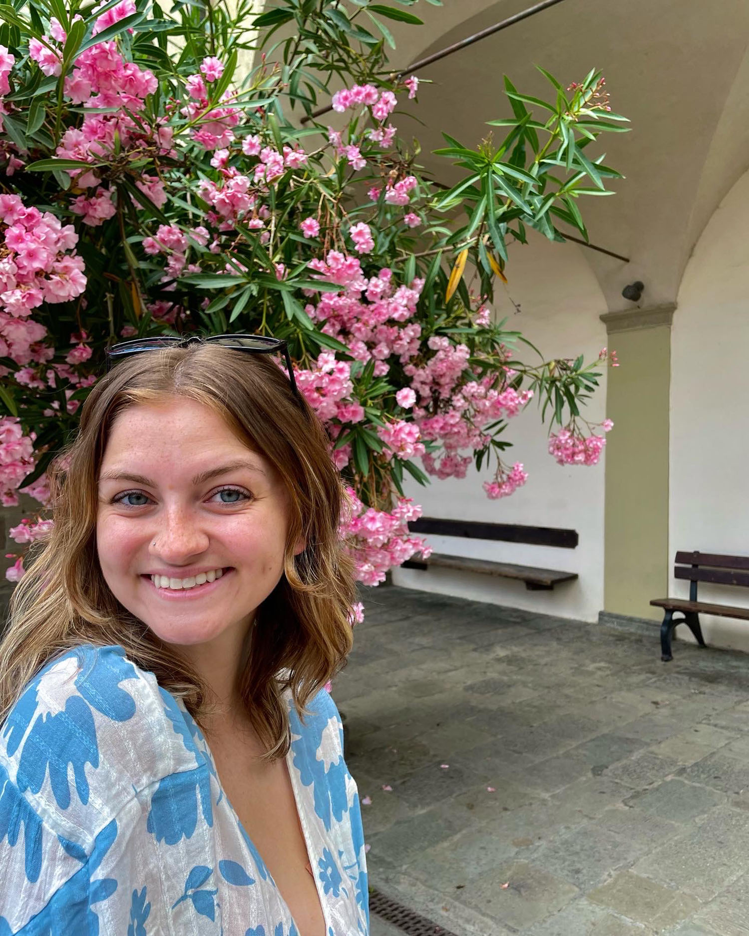 Alexis Bowser ’25MEd with a flowering tree behind her.
