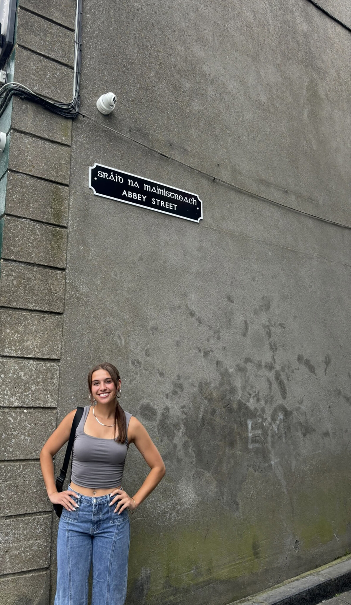 Abby Stephens ’26 standing below a sign reading "Abbey Street."
