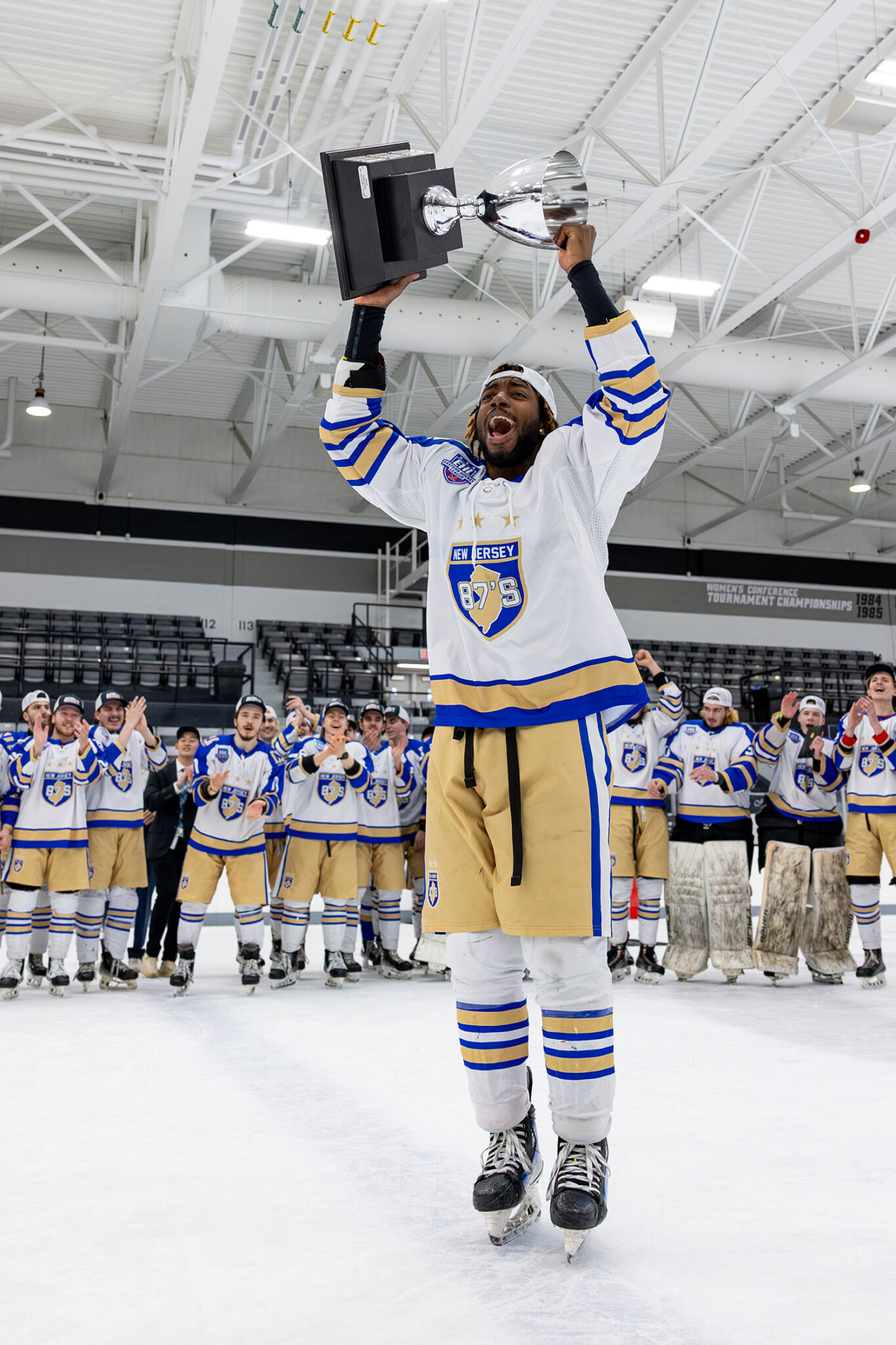Nate McFarlane ’29 holding a trophy over his head.