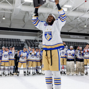 Nate McFarlane ’29 holding a trophy over his head.
