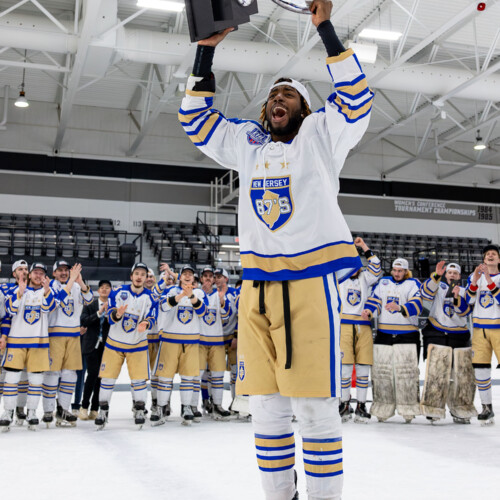 Nate McFarlane ’29 holding a trophy over his head.