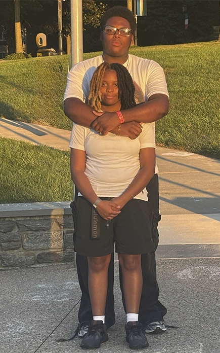 In a twighlight evening during their college years, twins Jada and James Northern stand together outside.