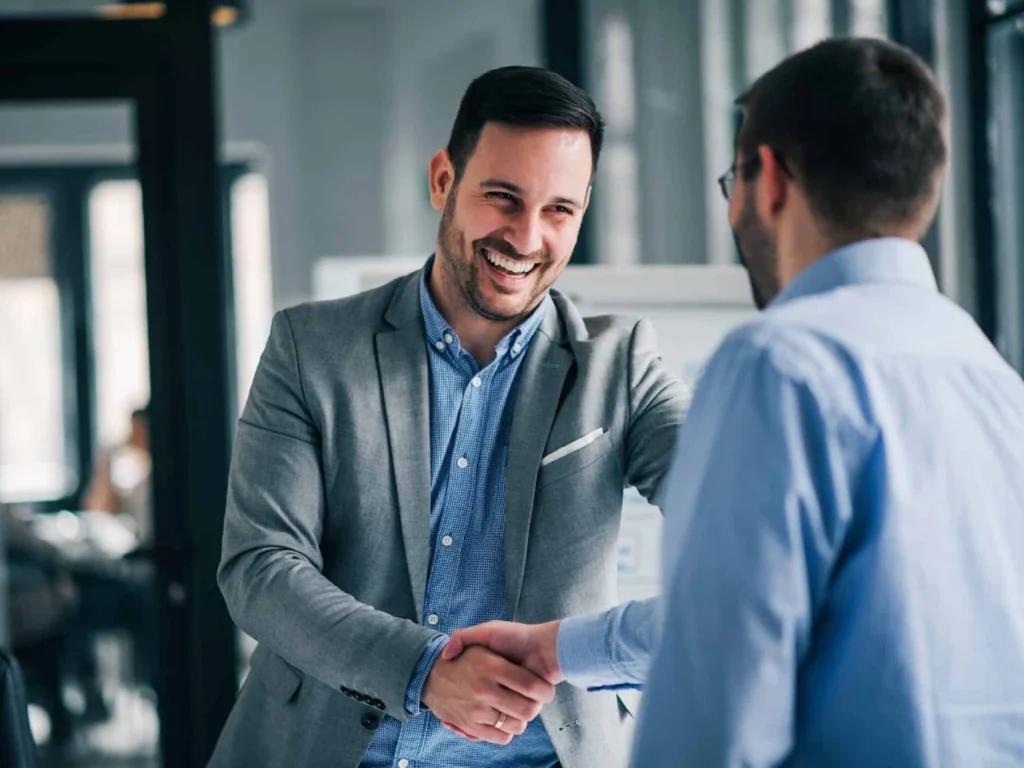Two businessmen shake hands.