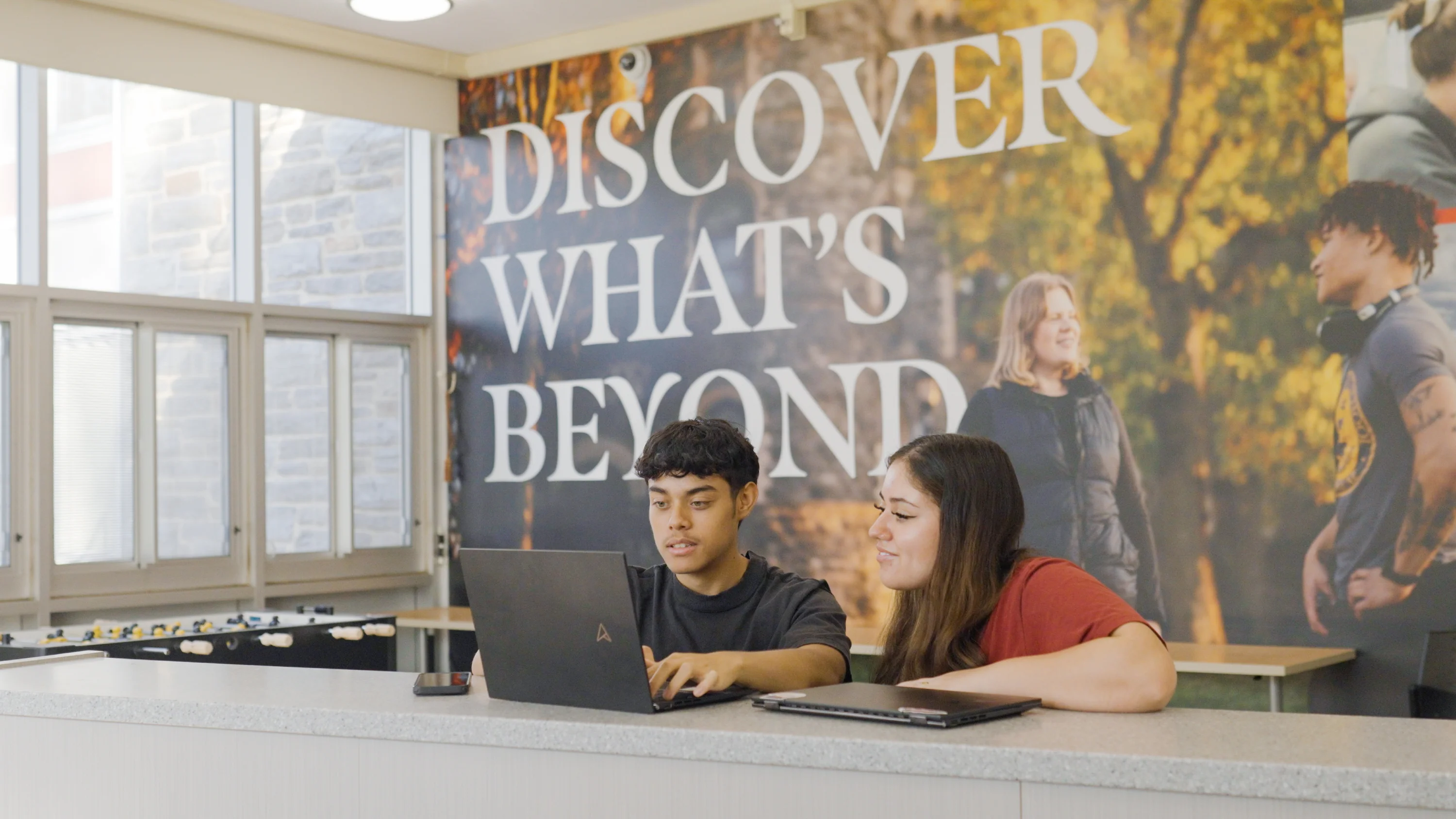Two students look at a laptop in Dilworth Hall.