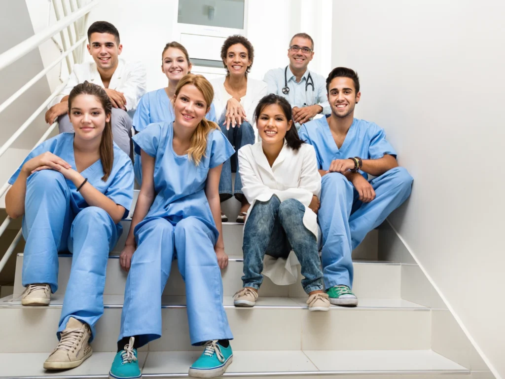Doctors and nurses sit on a staircase.