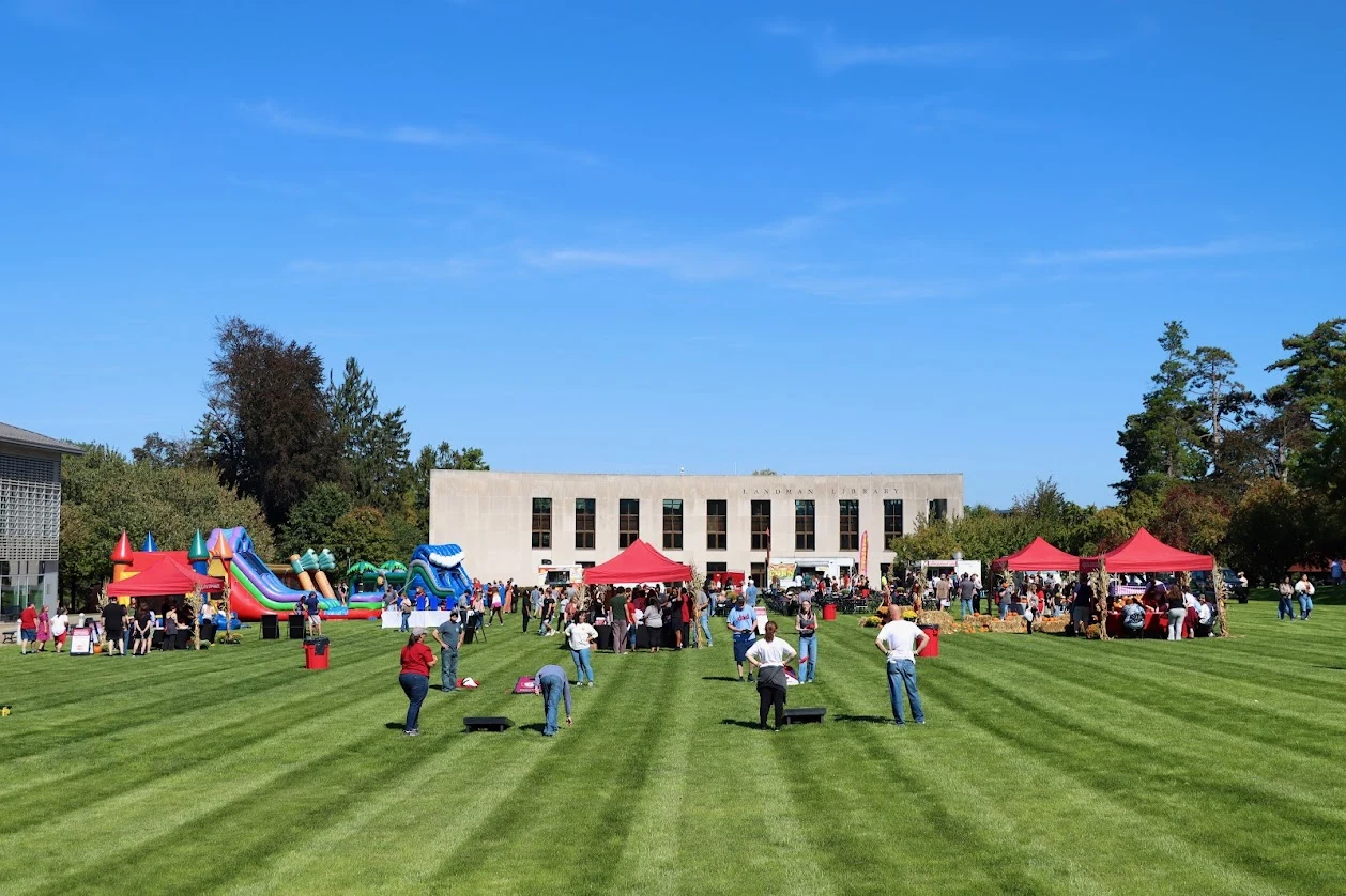 photo overlooking Haber Green with people enjoying lawn activities. The Landman Library is standing proudly in the distance.