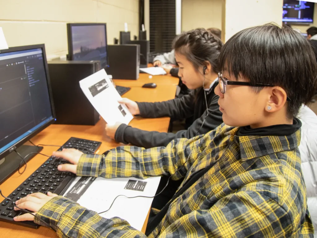 Students work on a project on their desktop computers in a computer lab.
