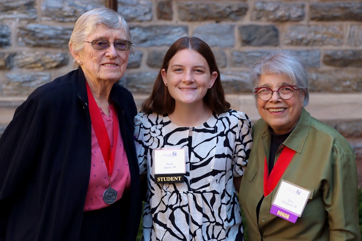 Two older women flank student scholarship recipients. All women are smiling.
