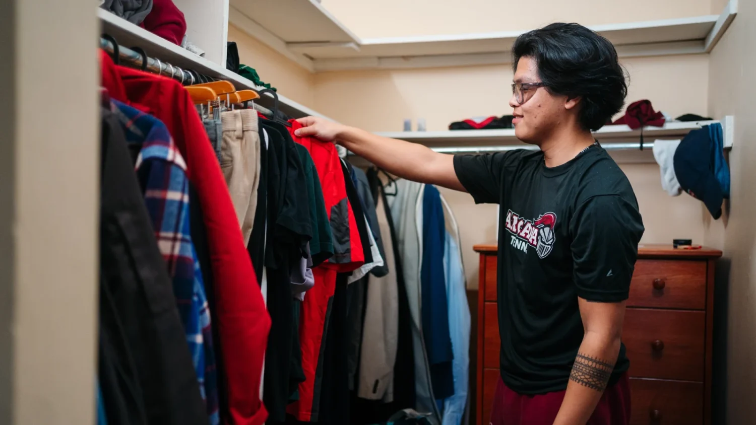 A student looking through clothes on a clothes hanger in the Residence Hall.