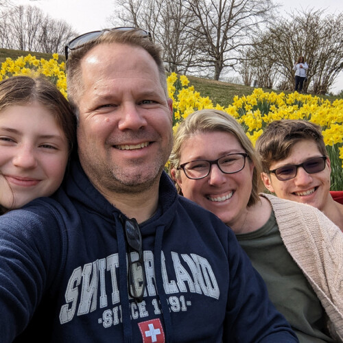 A family picture of the Orr family in front of yellow flowers