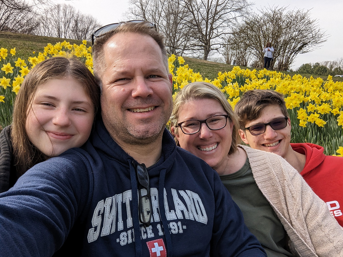 A family picture of the Orr family in front of yellow flowers