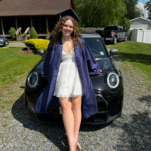 Alexa Casares ’29 sitting on a car.