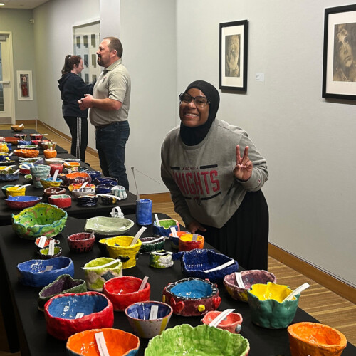 A student volunteer posing with some homemade bowls.