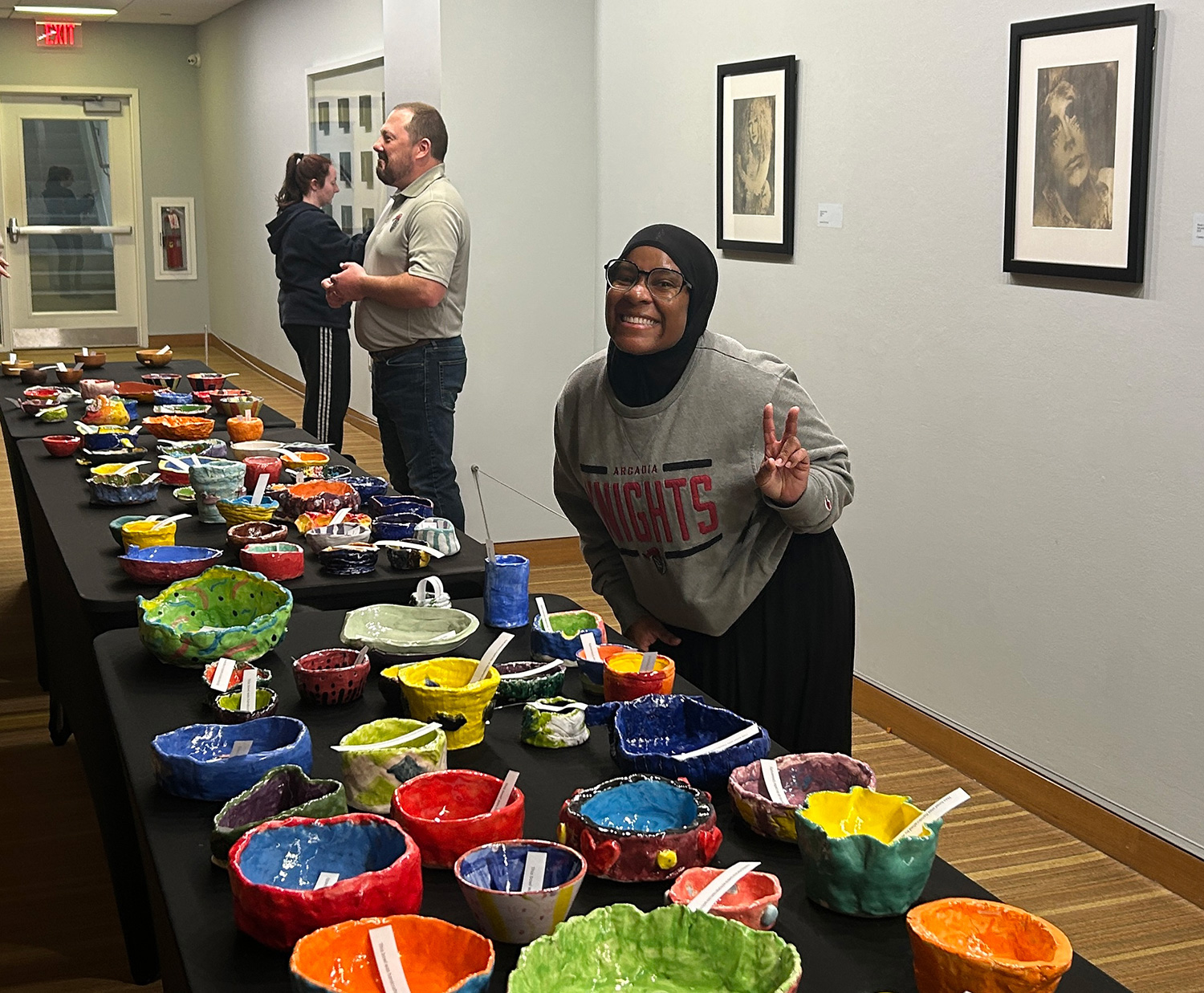 A student volunteer posing with some homemade bowls.