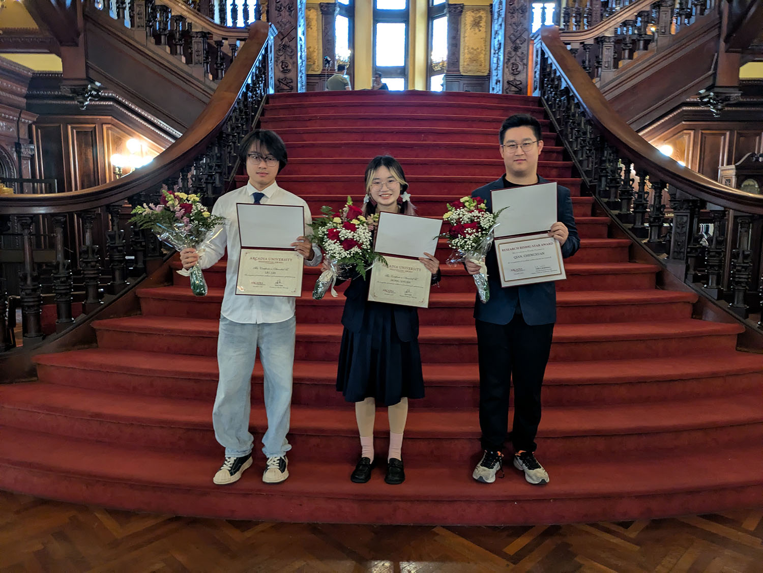 Chengxuan Qian ’26, Siyuan Hong ’27, and Lei Liu ’27 on the steps in the Castle.