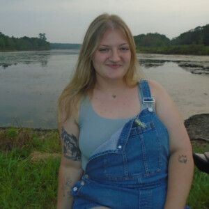 Emily Rooney ’29 standing in front of a lake.