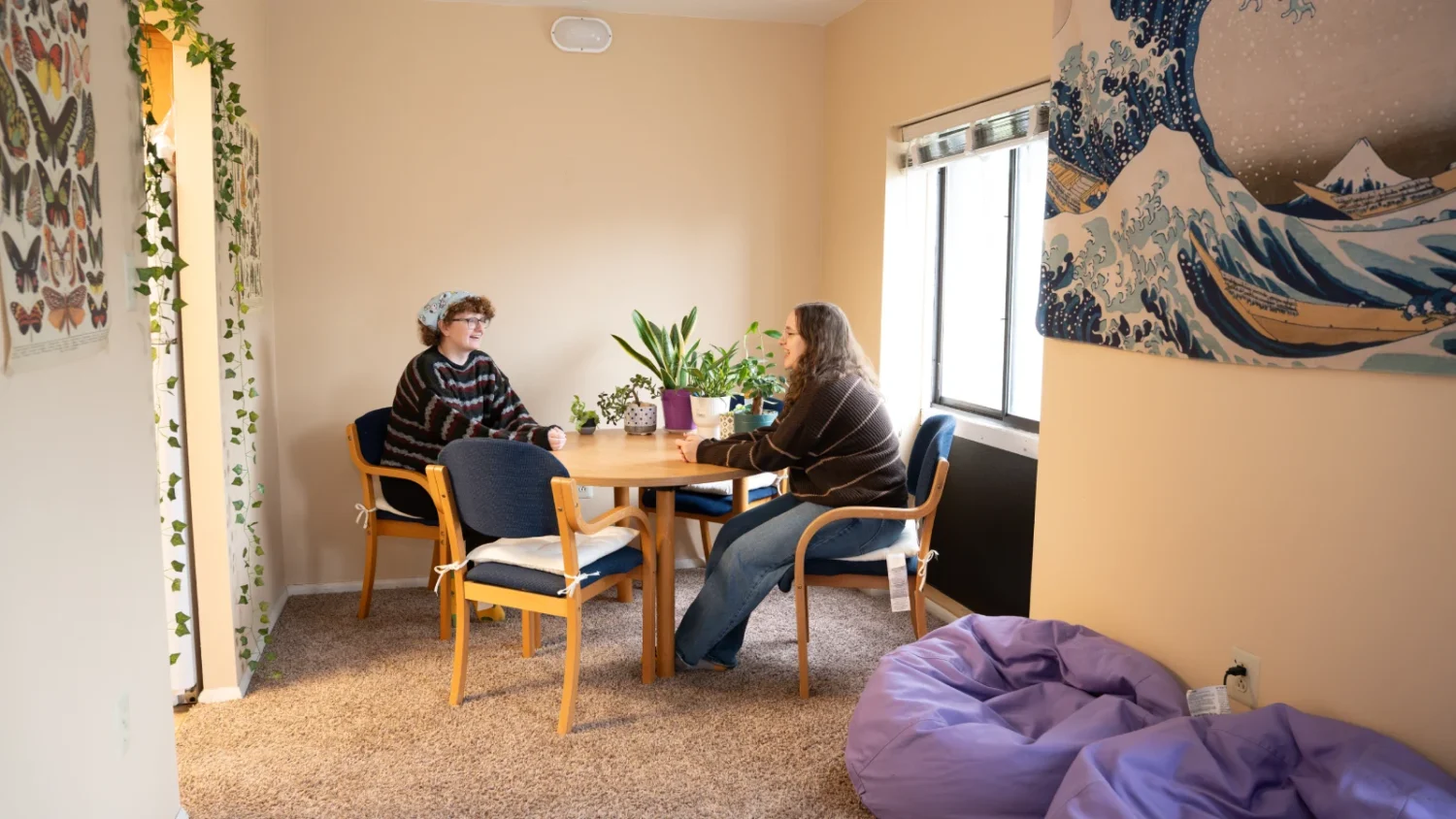 Two students converse at a table in the Oak Summit Apartments.