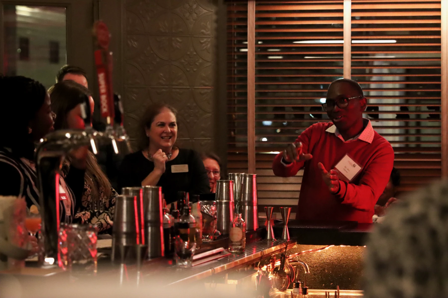 Alex Otieno speaks at a bar with faculty, staff, friends, and family.