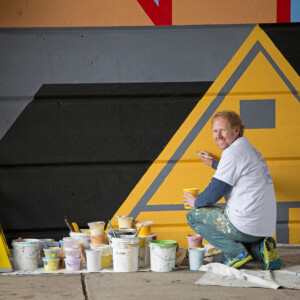 David Guinn working on a mural.