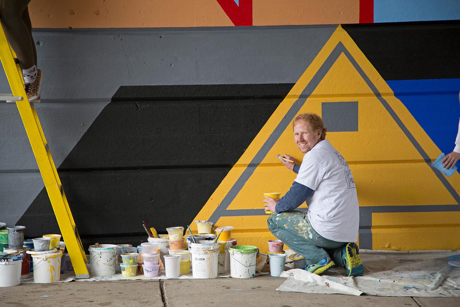 David Guinn working on a mural.
