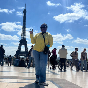 Simone Miller ’26M standing next to an Eiffel Tower replica.