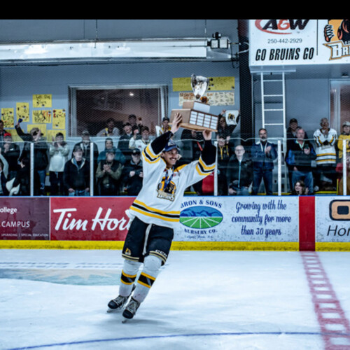 Theo Naidu ’29 holding a trophy on the ice.