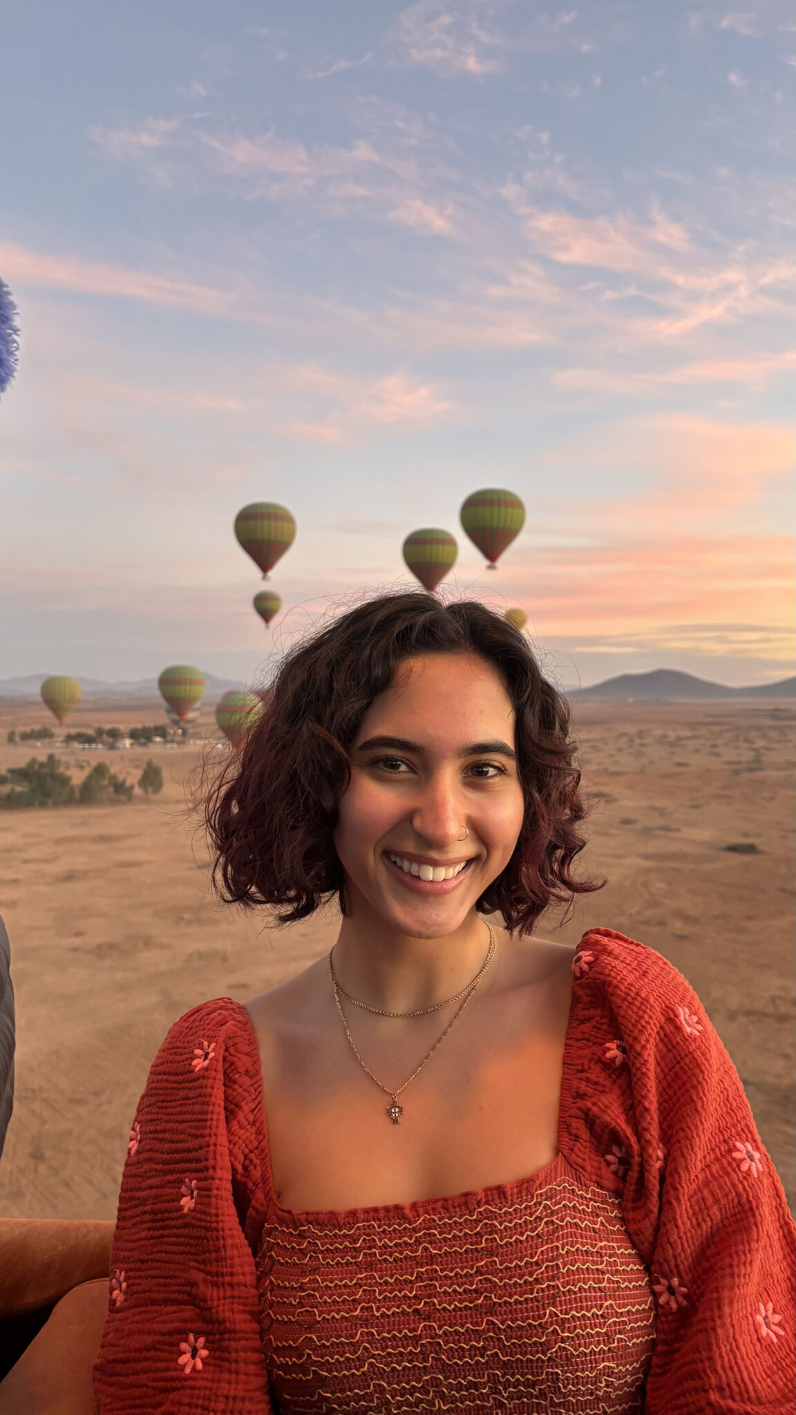 Briana Tavares ’26M with hot air balloons in the background.