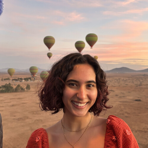 Briana Tavares ’26M with hot air balloons in the background.