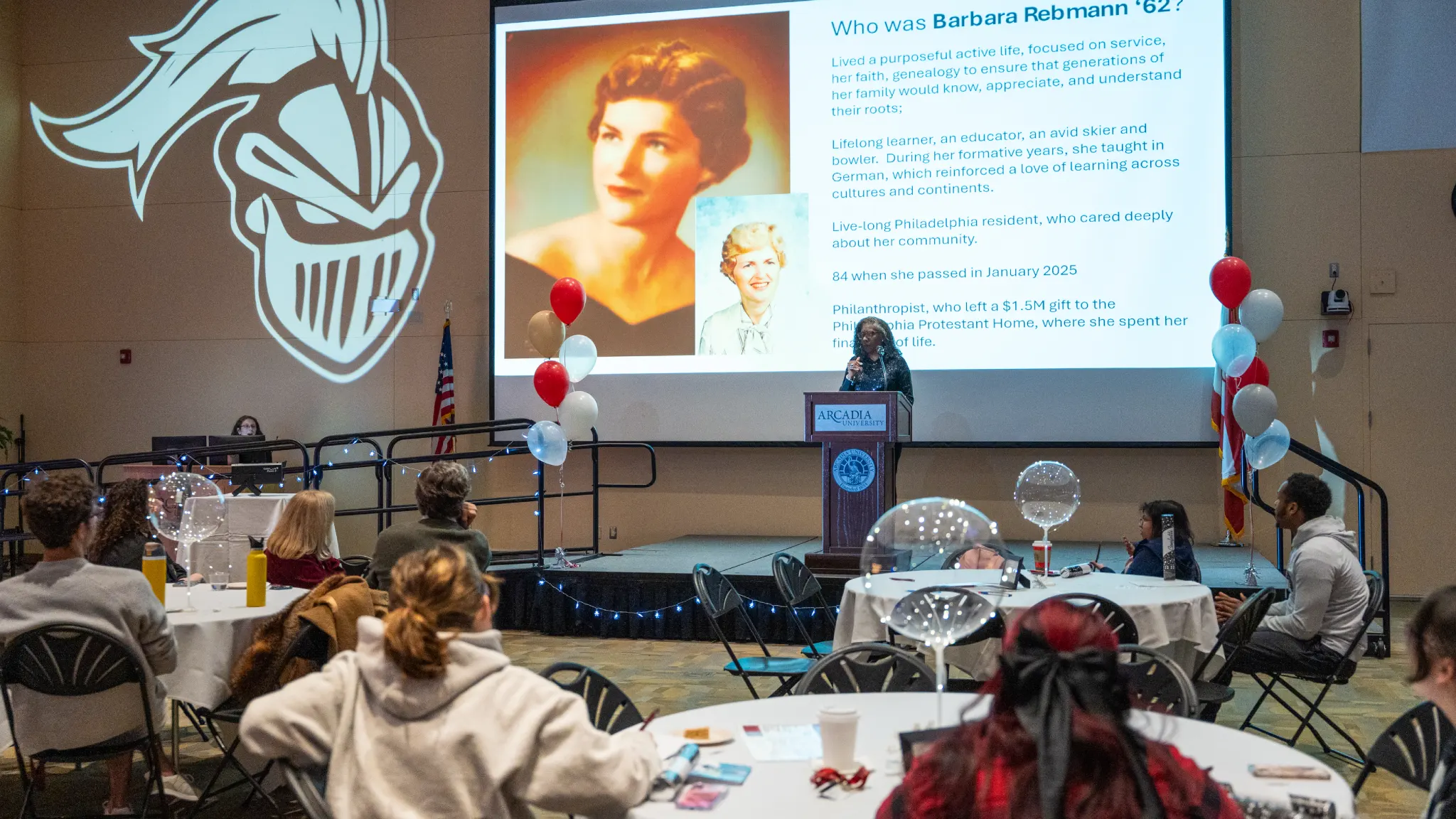 Students, alumni, and faculty listen to a presentation about an alumni at the Thank-a-thon.