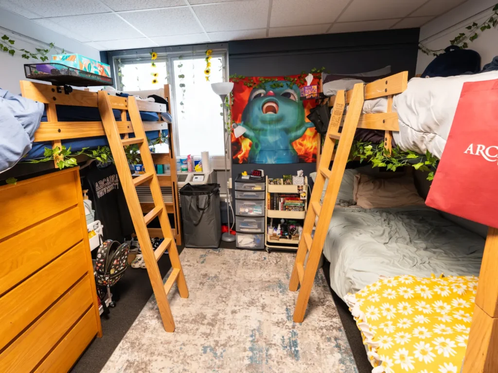 A view inside a triple room in Kistler Hall at Arcadia, where it is decorated with a banner of an animated character.