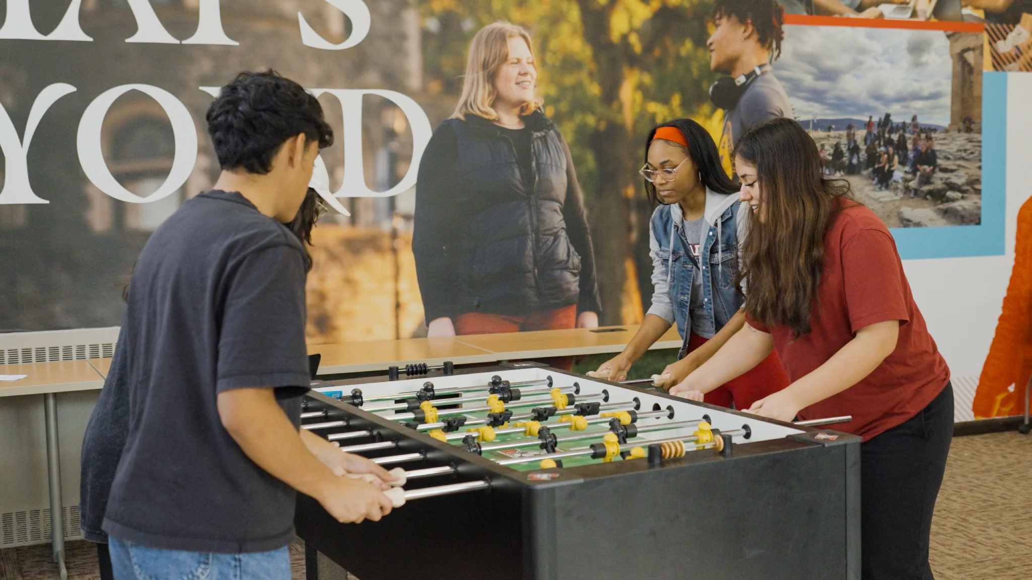 Four students play Foosball in the lounge at Arcadia.